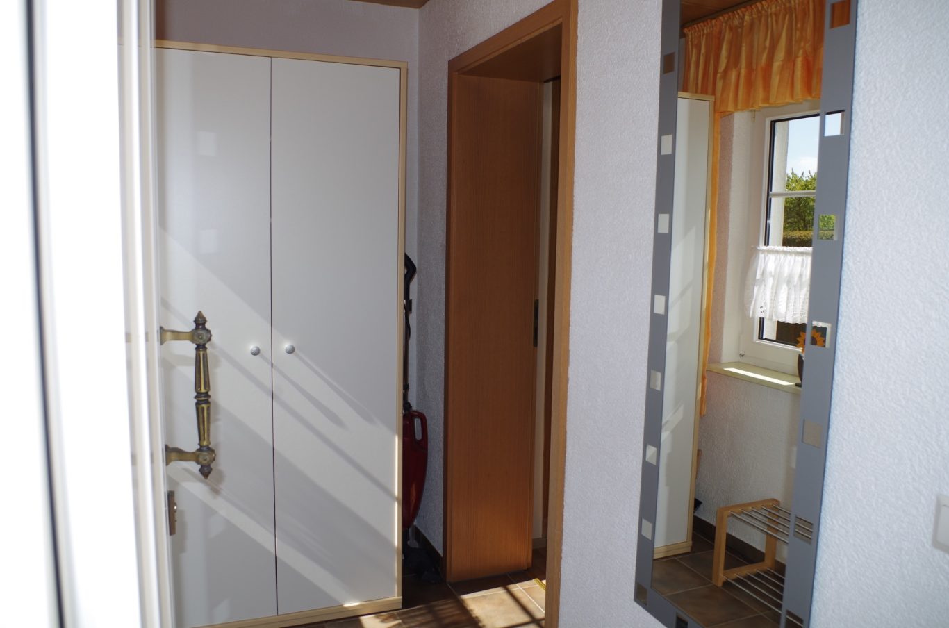 Flur mit Fenster, Kleiderschrank und Spiegel