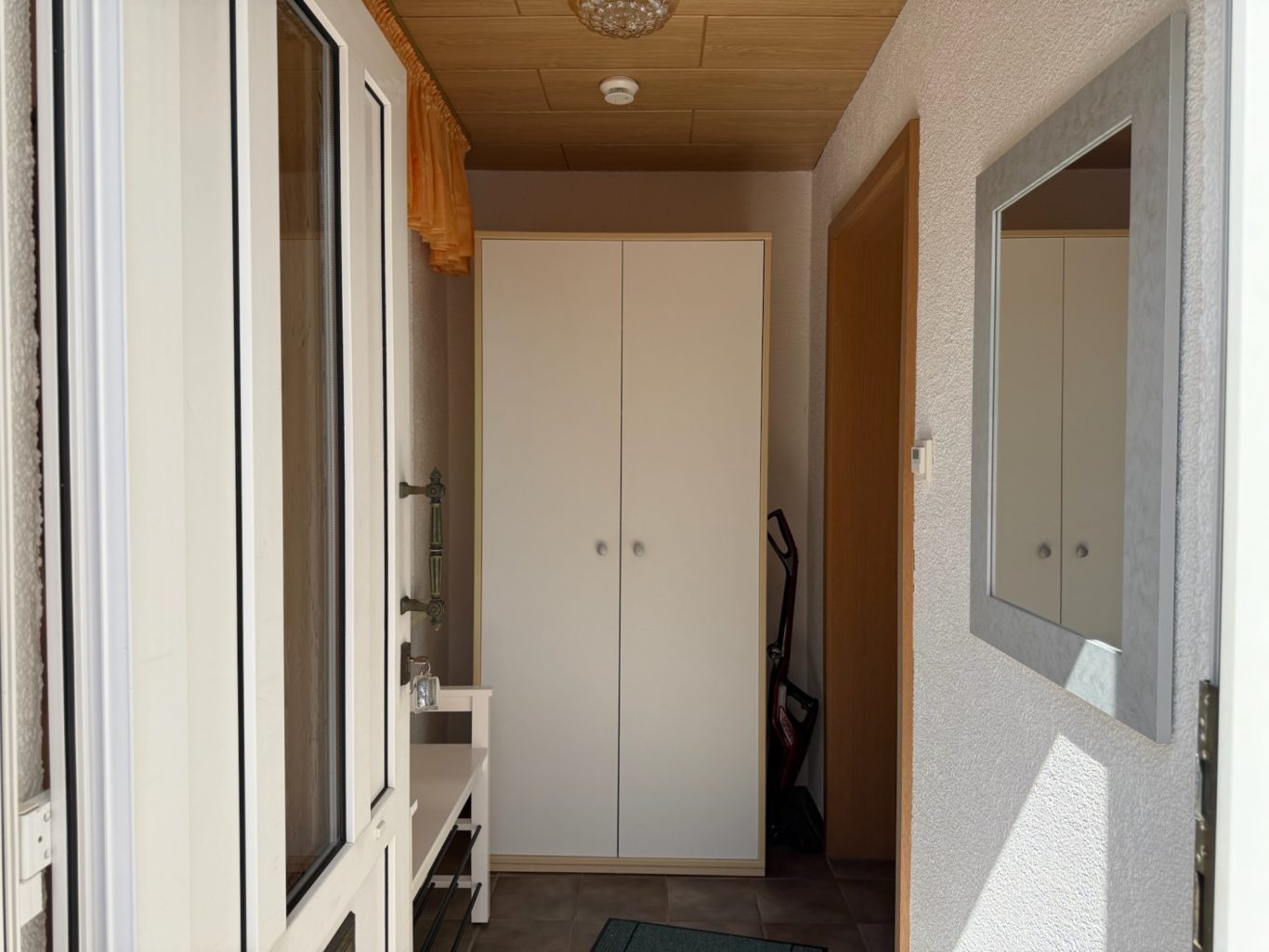 Flur mit Fenster, Kleiderschrank und Spiegel